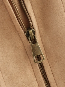Detailed macro of suede coat fabric texture and bronze metal zipper closure