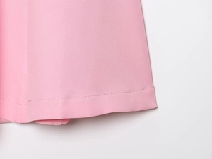 Close-up of pink woven dress hem with high-quality single needle flat stitching detail