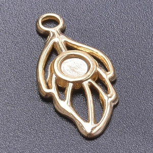 Macro shot of gold leaf pendant charm with round stone setting base for jewelry DIY