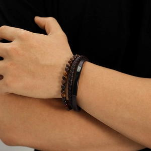 Close-up of tiger eye stone beads and multi-layer woven leather bracelet on wrist
