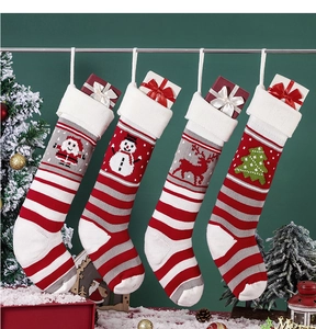 Detailed view of four knitted Christmas stockings with Santa, snowman, and reindeer patterns