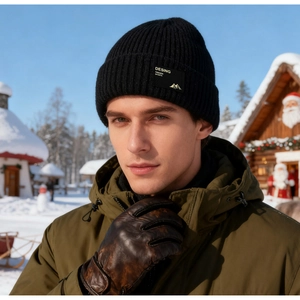 Detail der schwarzen Rippstrickmütze mit Logo-Aufnäher in winterlicher Outdoor-Umgebung