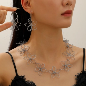 Detailed view of silver hollow flower necklace and earrings set worn by a model