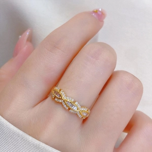 Primer plano de un anillo trenzado dorado adornado con circonitas blancas brillantes