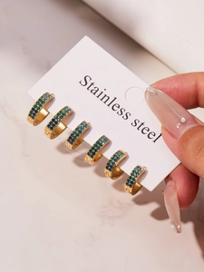 Three pairs of gold stainless steel C-shaped hoop earrings with blue rhinestones