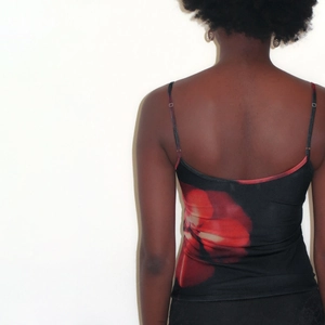 Detail of the back view showing the vibrant red floral print on the black camisole