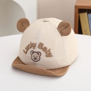Detailed view of baby cap featuring Lucky Baby embroidery and cute bear ears
