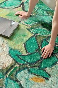 Detailed macro view showing the textured weave and green floral pattern of the round rug