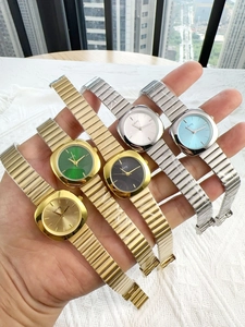 Close-up of gold and silver quartz watches with colorful square dials in hand