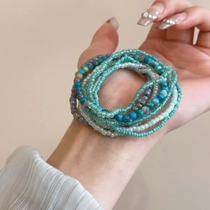 Detail of seven-piece bohemian multi-color seed bead bracelets worn on a wrist