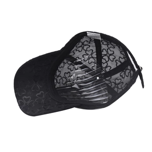 Detail of black lace baseball cap featuring breathable heart mesh pattern and wash label