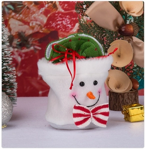 Detail of a plush snowman Christmas gift bag with festive holiday decor and accessories