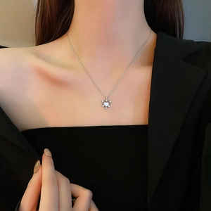 Close-up of heart-shaped zircon pendant necklace with crown design on female model