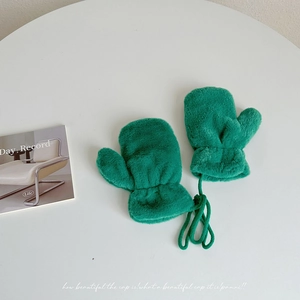 Detail of plush green winter mittens with a long neck strap for easy carrying