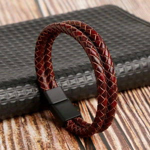 Close-up of double-layer brown woven leather bracelet with black magnetic metal clasp
