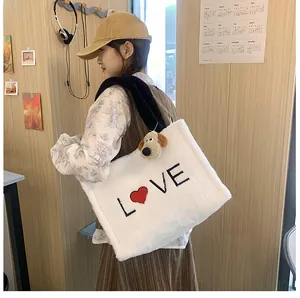 Detailed plush texture of white fleece tote bag with LOVE embroidery and dog charm