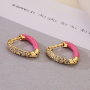 Macro detail of pink enamel and rhinestone pavé gold earrings with snap closure