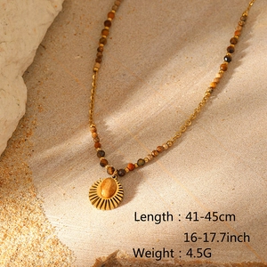 Detail of bohemian gold stainless steel necklace with natural stones and sun pendant