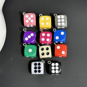 Top view of colorful miniature dice pendants in 11 shades with silver metal rings