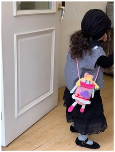 Dettaglio della borsa rosa fatta a mano all'uncinetto per bambini con bambolina