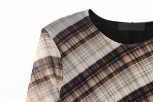 Detail of sheer plaid mesh neckline and shoulder straps on a slim fit long dress