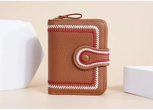 Detail of brown litchi pattern leather wallet with red and white stitching and a zipper