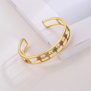 Detail of gold leopard bangle featuring colorful star-shaped zircons on an open band