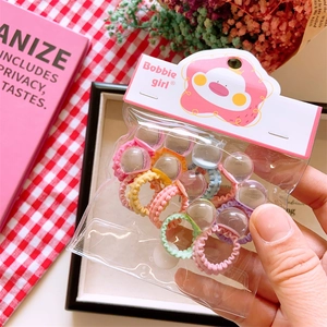 Close-up of colorful beaded elastic hair ties with transparent charms in a display pack