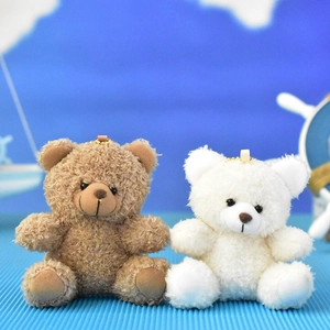 Detail showing two small plush teddy bears in brown and white with curly fur texture.