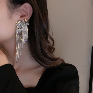 Close-up of sparkling rhinestone tassel earrings on model showing fringe details