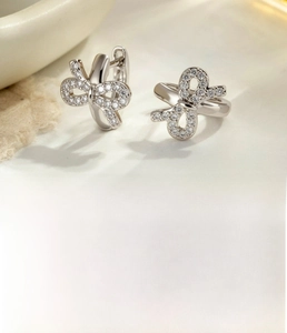 Macro detail of silver bow earrings with zircon pavé and 8mm inner diameter dimensions