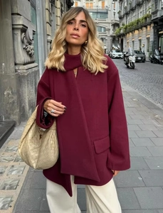 Detailed texture of burgundy wool coat fabric with lapel collar in street style