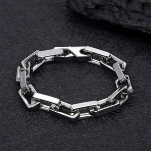 Nahaufnahme des industriellen Edelstahl-Kettenarmbands auf dunklem Steinhintergrund