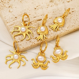 Golden octopus and jellyfish earrings with white pearls on elegant silk background