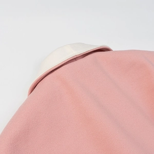 Close-up of pink wool blend coat featuring a contrasting cream white collar detail