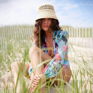Détail d'un cache-maillot à fleurs manches longues et d'un chapeau de paille à la plage