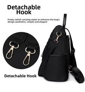 Detail of the detachable gold-tone metal hooks on a black quilted nylon backpack