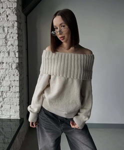 Detail view of cream off-the-shoulder knit sweater showing vertical striped collar texture