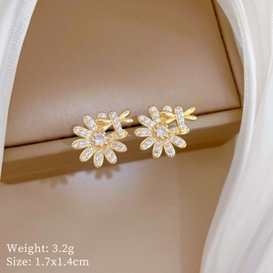 Macro shot of gold daisy earrings with white cubic zirconia on silk, size 1.7x1.4cm