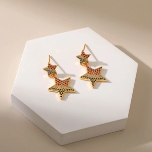 Bohemian gold star earrings with colorful cubic zirconia on a marble display