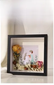 Detail of deep shadow box frame with 3D dried flowers and couple illustration