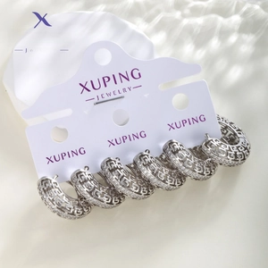 Close-up of silver hollow geometric earrings with micro-inlaid rhinestones on jewelry card