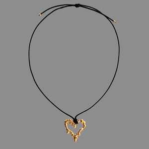 Close-up of golden lava texture heart pendant on minimalist black cord necklace