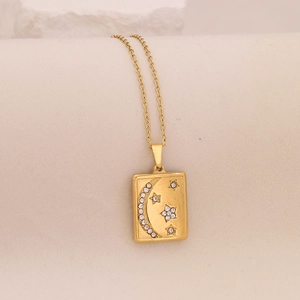 Detailed macro view of a gold star and moon rectangular pendant with clear crystals