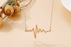 Close-up of rose gold electrocardiogram pendant necklace with delicate chain detail