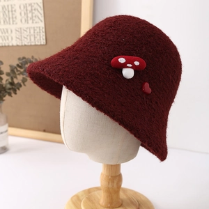 Detail of burgundy plush bucket hat with cute mushroom patch and heart on a model head
