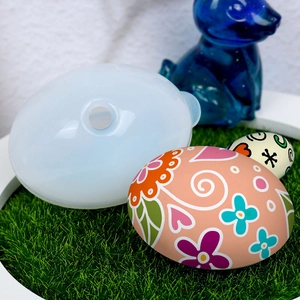 Close-up of translucent silicone egg mold for resin crafts with a colorful egg sample