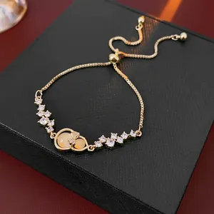 Elegant 18K gold-plated zircon bow and gourd bracelet with opal inlay on black jewelry box