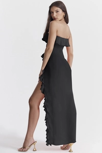 Détail du décolleté à volants bustier et fente haute sur robe de soirée noire chic