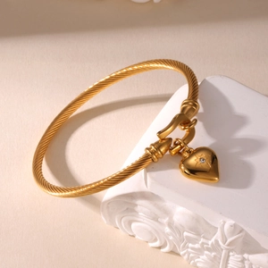 Gold-plated stainless steel cable heart bracelet with a sparkling crystal center stone